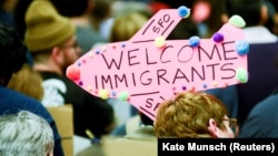 Demonstrators hold welcome signs for immigrants at San Francisco's international airport on January 28 as anger mounted over President Donald Trump's executive order. 