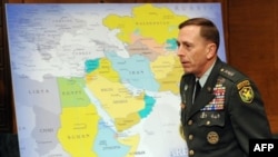 Petraeus walks by a map of what will be his area of responsibility.