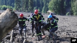 Rescue workers carry the body of a victim of a landslide, near Shovi, about 140 kilometers northwest of Georgia's capital, Tbilisi, on August 4.