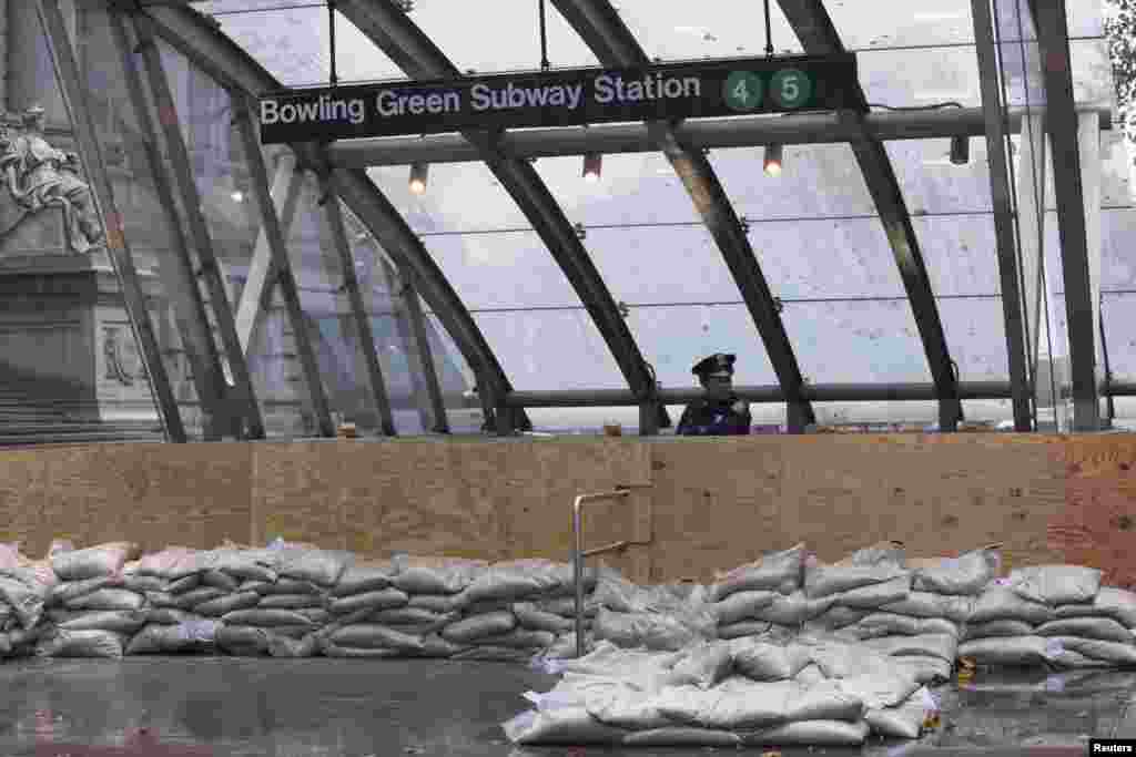 A New York Police officer guards a closed subway entrance in downtown Manhattan as Hurricane Sandy makes its approach in New York.&nbsp;