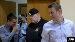 Aleksei Navalny (right) enters the court room for the verdict.