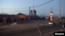 Police stand near debris at the site of a suicide bombing at a checkpoint on the border between the regions of North Ossetia and Ingushetia in October 2012.