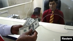 A customer counts his money after making a withdrawal at Azizi Bank's main branch in Kabul. (file photo)