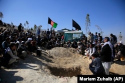 Afghan men attend the funeral of one of the victims of an October 24 suicide attack that targeted an education center in Kabul the day before.