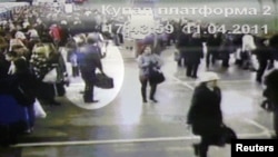 A screenshot from video surveillance cameras in the Minsk subway of a suspect (top left) carrying a bulky sports bag on April 11.