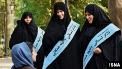 Female members of the notorious morality police known as the Guidance Patrols stop to talk to a woman in Tehran. 