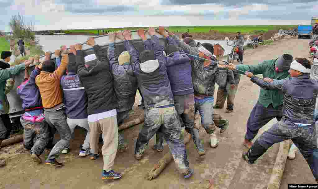 Rescuers drag a motorboat out of the water in Northern Iran. On March 26 a boat overturned while carrying volunteers and victims near Aq Qala. At least five people have been found dead.