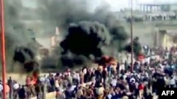 Thick smoke rises as antigovernment protesters demonstrate in Moaret Al-Noman, Syria, in late April.