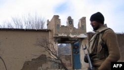 A soldier stands beside a damaged Taliban militant training center in Makeen, South Waziristan.