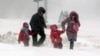 A couple with children walk during a heavy snow storm in central Minsk last week. Despite the fact that spring has now officially arrived, much of the northern hemisphere remains covered in snow. 