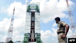 An Indian security troop patrols near the PSLV-C25 launch vehicle, carrying the Mars Orbiter probe as its payload, at the Indian Space Research Organization facility in Sriharikota on October 30.