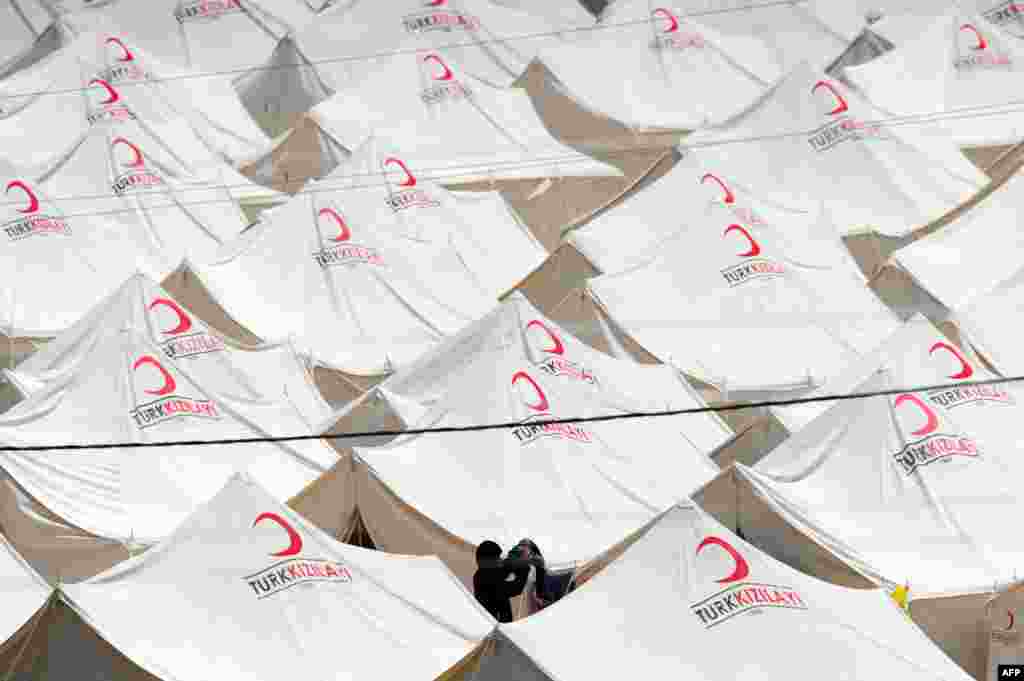 A Syrian woman hangs laundry out to dry at the Boynuyogun Red Crescent refugee camp in the Altinozu district of Hatay, in southern Turkey.