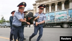 Арнайы жасақ ұсталғандардың бірін көлікке күштеп салып жатыр. Алматы, 9 маусым 2019 жыл. 