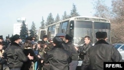 Police arresting demonstrators in Almaty and loading them on a bus