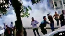 YouTube footage shows antigovernment protesters running for cover from tear gas fired by security forces in the capital Damascus