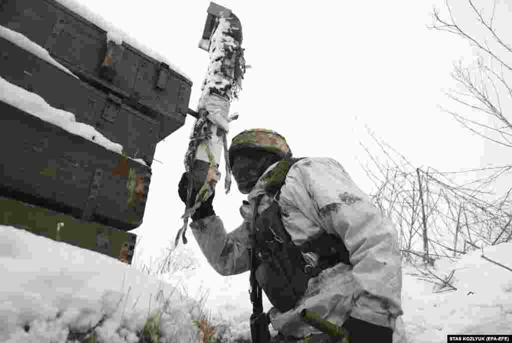 A Ukrainian soldier monitors the situation on January 29 from a trench using a periscope near the city of Donetsk, which is controlled by Kremlin-backed separatists.