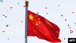 China -- Released balloons float over the Chinese national flag during a military parade over Tiananmen Square in Beijing on September 3, 2015