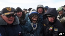 Ailing? Russian space agency rescuers help cosmonaut Aleksandr Kaleri shortly after his landing near the town of Arkalyk, in Kazakhstan on March 16.