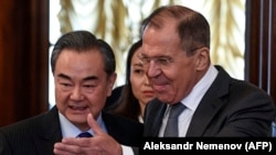 Russian Foreign Minister Sergei Lavrov (right) shows the way to Chinese counterpart Wang Yi during a meeting in Moscow on April 5.