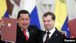 Russian President Dmitry Medvedev (right) and his Venezuelan counterpart Hugo Chavez show signed documents during their meeting in Moscow on October 15.