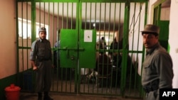 Prison wardens stand guard during a visit by local and international media at Pul-e Charkhi prison on the outskirts of Kabul