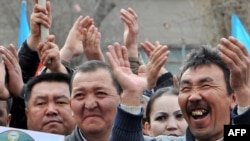 Opposition supporters cheer during a rally in Bishkek on March 17.