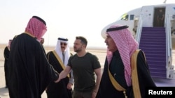 Ukrainian President Volodymyr Zelenskiy is welcomed upon arriving at an airport in an unknown location in Saudi Arabia on February 27.