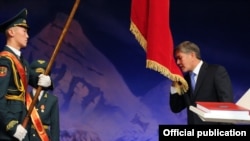 Almazbek Atambaev kisses the Kyrgyz flag during his presidential inauguration ceremony in Bishkek on December 1.