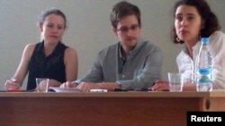 Edward Snowden (center) and Sarah Harrison (left) of WikiLeaks speak to human rights representatives in Moscow's Sheremetyevo Airport earlier this month.