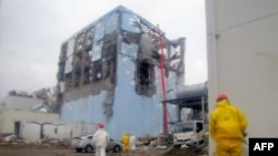 A Tokyo Electric Power Company handout photo of a worker spraying water to cool spent nuclear fuel at the reactor No. 4 building at Fukushima Daiichi nuclear plant (released on March 22).