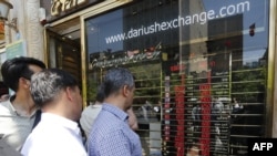 Iranians check exchange rates outside a bank in Tehran.