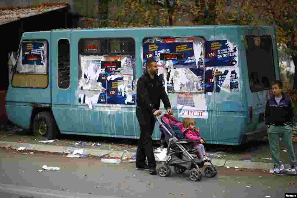 A man walks with children approaches a polling station in northern Mitrovica.