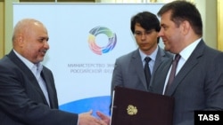 Iranian Oil Minister Masoud Mirkazemi (left) and Russian Energy Minister Sergei Shmatko shake hands on July 14 in Moscow.