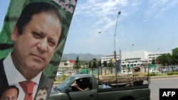 A Pakistani Army vehicle drives past a poster of Prime Minister Nawaz Sharif in Islamabad.