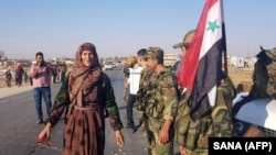 Syrians welcome regime forces at the western entrance of the town of Tal Tamr Syria's northeastern Hasakeh Province on October 14.