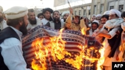 Supporters of hardline pro-Taliban party Jamiat Ulema-i-Islam-Nazaryati burn a U.S. flag during a protest in Quetta