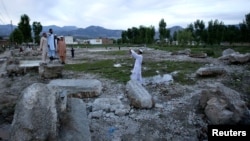 A man takes a picture of his friends on the demolished site of the compound of Osama bin Laden in Abbottabad in May.