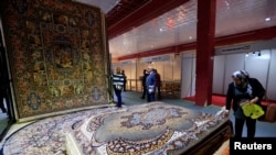 People look at the carpets displayed at the Iran section of the Baghdad International Fair on November 10.