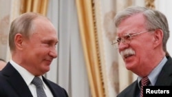 Russian President Vladimir Putin (left) shakes hands with U.S. national-security adviser John Bolton in Moscow.