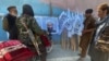 Members of Taliban forces gather and look at a poster of their reclusive leader, Mullah Mawlawi Haibatullah Akhundzada, shortly after the militant group's takeover of Kabul in August. 