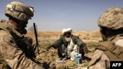 An Afghan farmer speaks with a U.S. Marine officer in Marjah in 2010.