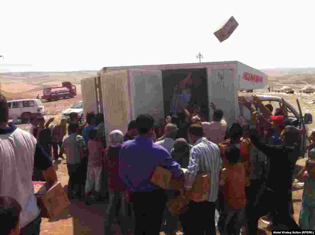 Emergency aid packages are thrown to the crowd.