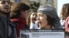 A protester carries a sign referring to Tunisia's ousted president and Egypt's Hosni Mubarak at a demonstration in Beirut. Are such activists reacting to the State Department push for dialogue?