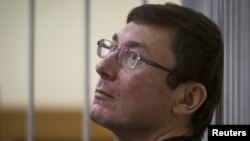 Former Interior Minister Yuriy Lutsenko looks on from the defendant's cage as he attends court session in Kyiv last year.