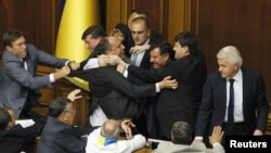 The speaker of the Ukrainian parliament, Volodymyr Lytvyn (right), looks on as deputies scuffle during debate over the draft law on languages.