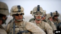 U.S. Marines await helicopter transport in Helmand Province, Afghanistan.