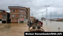 Military vehicles rescue people after floods around the northern Iranian city of Aq Qala.