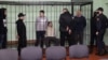 (Left to right:) Dzmitry Papou, Artsyom Sakau, Uladzimer Tsyhanovich, Ihar Losik, Syarhey Tsikhanouski, and Mikalay Statkevich in the defendants' cage during the court hearing where they were sentenced in Homel on December 14.