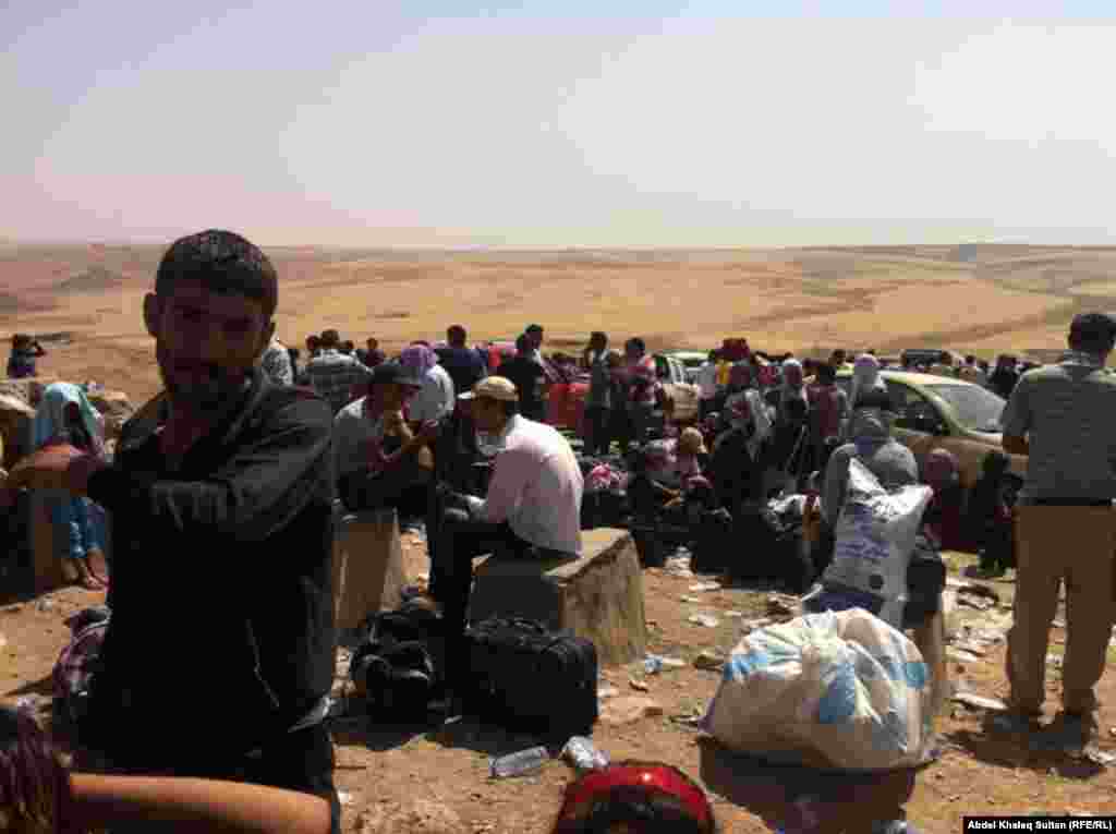 Kurdish refugees wait on the Iraqi side of the border after arriving from Syria. 