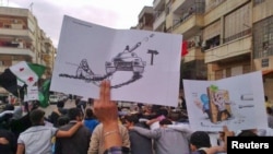 Syrian antiregime protesters marching through the streets of Homs last week.